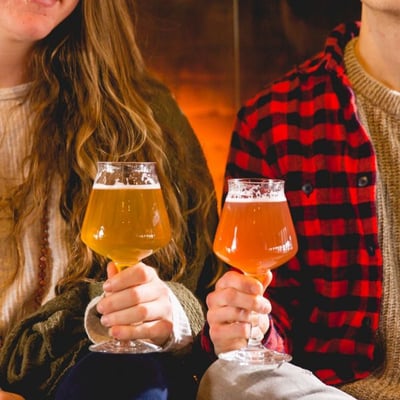 Two friends drink beers out of Teku glasses