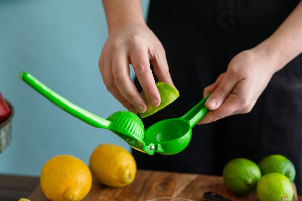Lime being placed into handheld juicer